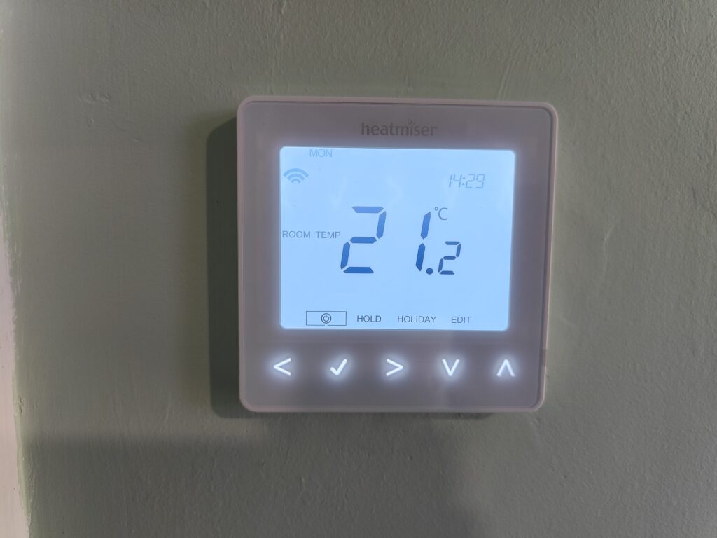 A room thermostat showing a temperature of 21.2c, not currently calling for heat